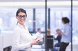 © .shock - Elegant Woman Using Mobile Phone in startup office building