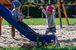 © Rajtar photography - Rodzeństwo dzieci bawi się na planu zabaw w jesienny słoneczny dzień.