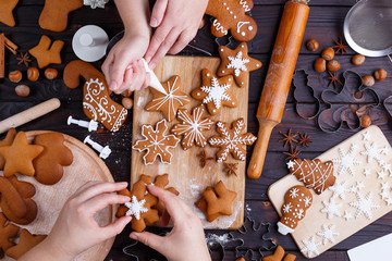 Canvas Print - Christmas bakery. Friends decorating freshly baked gingerbread c