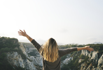 Wall Mural - Carefree woman arms outstretched on the mountain