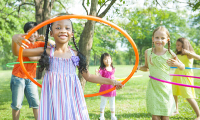 Cute diverse kids playing with hula hoops