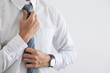 © Freedomz - Close up of Young attractive businessman wears a gray tie and adjusting tie