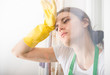 © Catalin Pop - Tired woman with protective gloves wiping her forehead