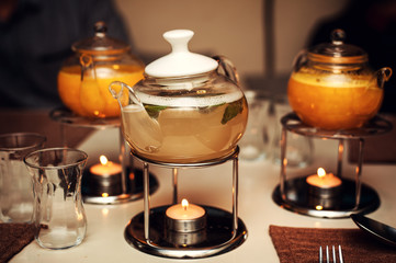 horizontal  image with three teapots with yellow fruit tea