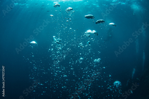 Plakat Podwodny strzał błękitna ocean woda, lotniczych bąbli zbliżenie, sunbeams na wody powierzchni, niektóre scubadivers w głębokim
