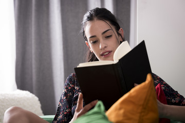 Wall Mural - Smiling young excited woman with book