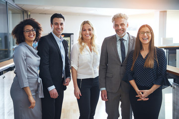 Diverse group of smiling colleagues standing together in an office