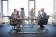 Diverse colleagues talking together in a boardroom in an office
