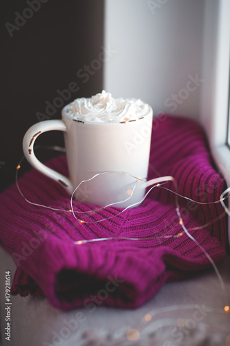 Zdjęcie XXL Poranna kawa z kremem na sweter z dzianiny z girlandą stwierdzającą na parapecie. Dzień dobry. Okres świąteczny.