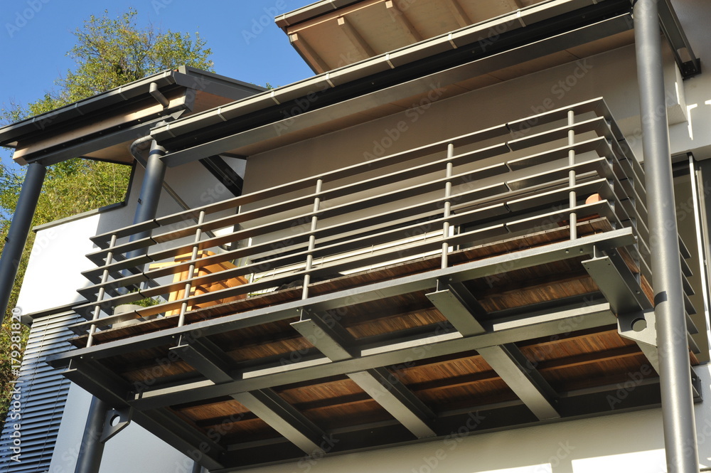 Stahl-Balkon mit Überdachung an moderner Hausfront - obrazy, fototapety, plakaty 