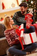 Wall Mural - Male giving Christmas socks to female