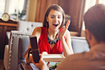 Wall Mural - Romantic couple dating in restaurant and giving present