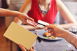 © Kalim - People paying in restaurant by credit card reader
