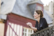© Mike Kemp/Blend Images - Caucasian woman drinking coffee on balcony in city