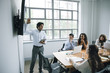 © John Fedele/Blend Images - Businessman explaining presentation to colleagues in business meeting