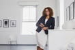 © Strauss/Curtis/Blend Images - Mixed race woman texting on cell phone in gallery
