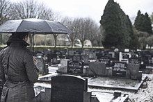 Widow Woman Visiting Graveyard In The Rain