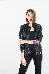 Wall Mural - Modern young woman in fashionable black outfit and red lipstick posing on white background.