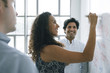 © John Fedele/Blend Images - Businesswoman writing on whiteboard in meeting