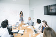 © John Fedele/Blend Images - Businesswoman talking at whiteboard in meeting