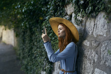 Caucasian Woman Photographing With Cell Phone Near Stone Wall