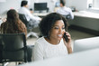 © John Fedele/Blend Images - Businesswoman talking on smartphone while sitting in office