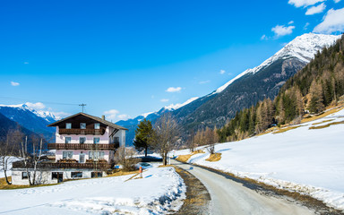 Wall Mural - Amazing view of winter wonderland mountain scenery with traditional mountain chalet in the Alps on a sunny day with blue sky