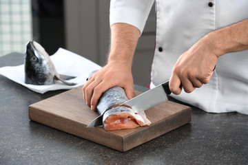 Poster - Chef cutting fresh salmon in kitchen