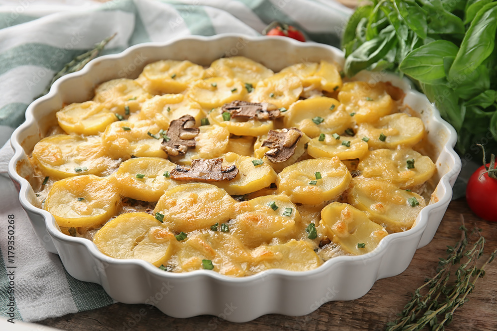 Baking dish with potato casserole on table