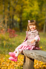 happy little child, baby girl laughing and playing in the autumn on the nature walk outdoors