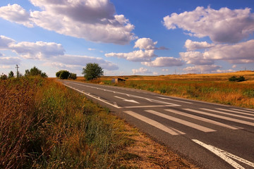  Road and blue sky with clouds i the end of the summer