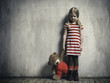 © kozorog - Sad girl with a toy bear on a background of textured walls. The concept of children's resentment, the complexity of education, the child's behavior