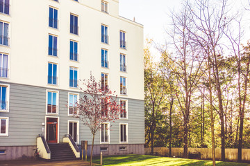 Wall Mural - modern white apartment building with autumn tree in park