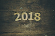 © xlibes - Text 2018 on a brown wooden background with vintage effect