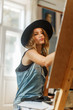 © proimagecontent - Female artist wears black hat draw picture indoor the studio