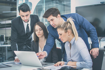 Wall Mural - Group of business people using laptop and cooperating on a meeting.