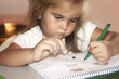 © larisa - a little girl draws pictures sitting at home