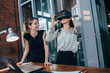 © undrey - Two female application developers testing a new app designed for VR headset standing in modern office