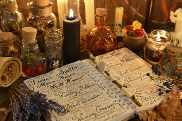 Wall Mural - Magic book with spells, lavender bunch and black candle on witch table.