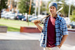 © Sergey Nivens - Teenage boy with skateboard standing outdoors