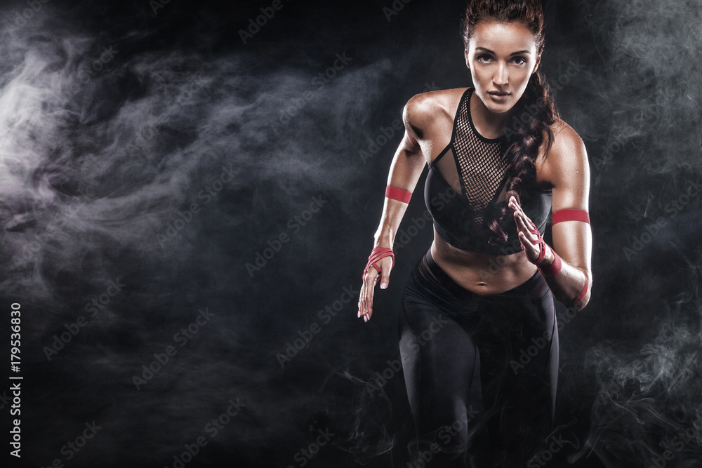A strong athletic, woman sprinter, running on black background wearing in the sportswear, fitness and sport motivation. Runner concept with copy space. - obrazy, fototapety, plakaty 