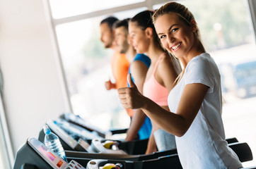 Wall Mural - Group of friends exercising on treadmill machine