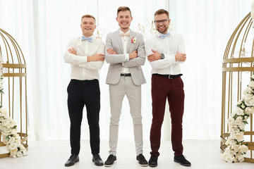 Wall Mural - Happy handsome groom with best men on wedding day, indoors