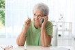 © Africa Studio - Elderly woman speaking on cell phone at home