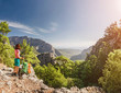 © EdNurg - Young hiker woman standing on cliff's edge and looking into a Goynuk canyon in Turkey. Lycian Way travel concept