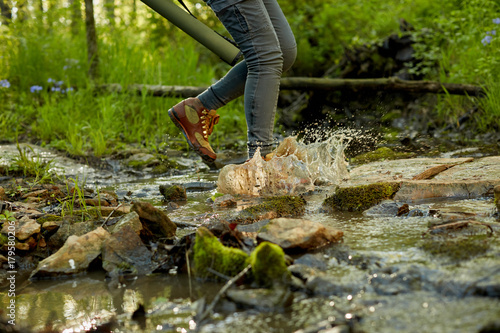 Fotografie, Obraz Female hiker splashing through a forest stream