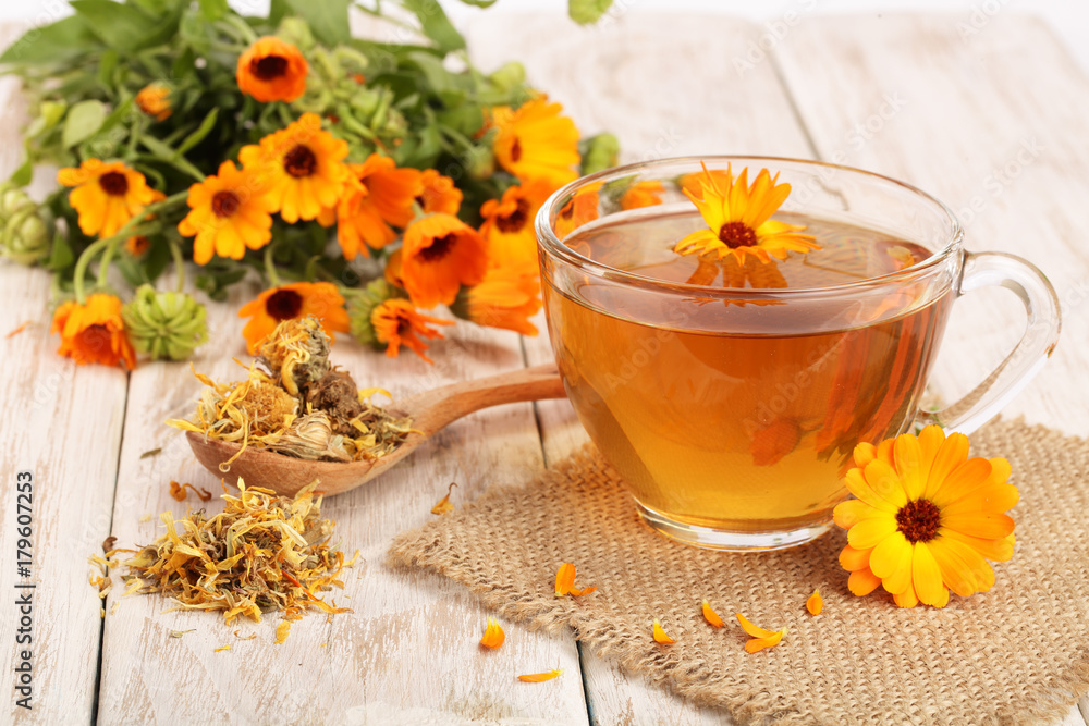 Calendula tea with fresh and dried flowers on white wooden background - obrazy, fototapety, plakaty 