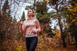 © maryviolet - Young woman running in autumn forest