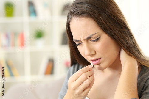 Woman suffering neck ache eating a pill Tableau sur Toile