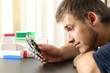 © Antonioguillem - Doubtful man holding a lot of medicines